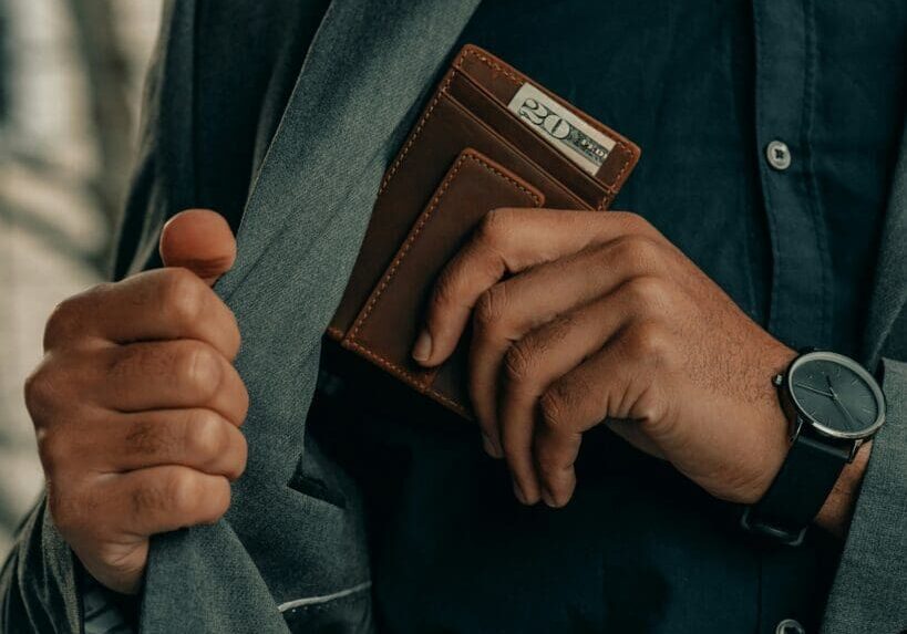 Person holding wallet in suit pocket
