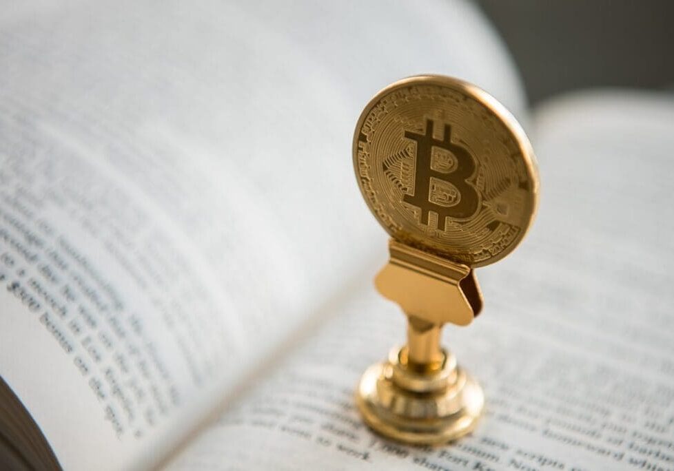 Bitcoin symbol atop open book pages
