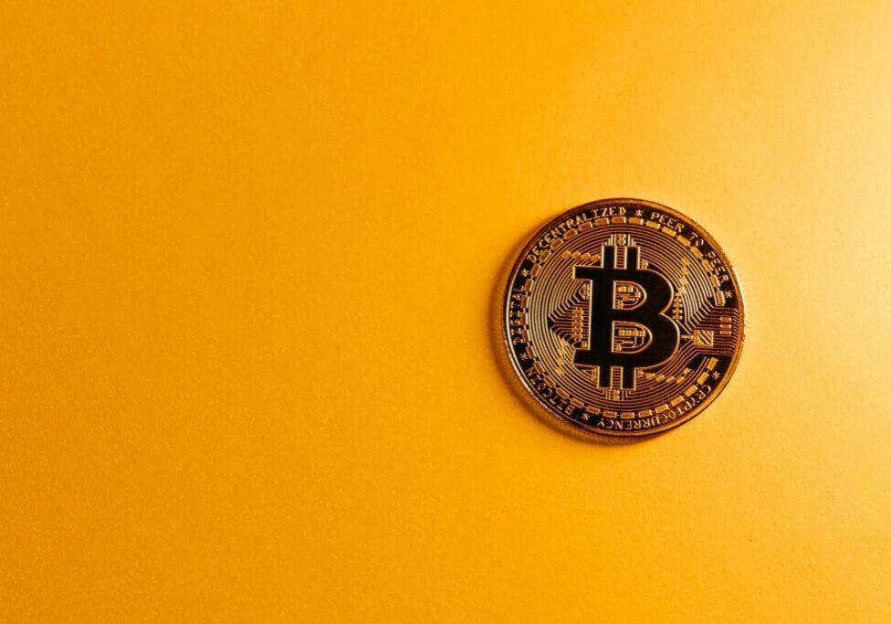 bitcoin-coin-on-yellow-background-scaled
