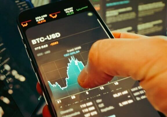 Crypto trading on smartphone and laptop displays