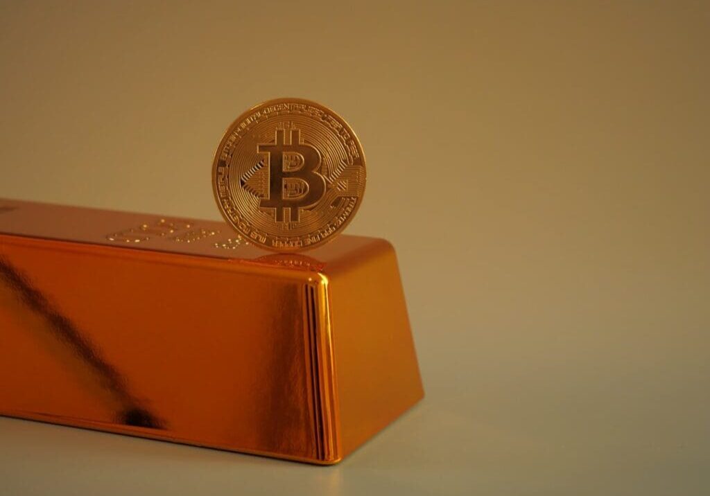 Bitcoin coin on gold bullion bar