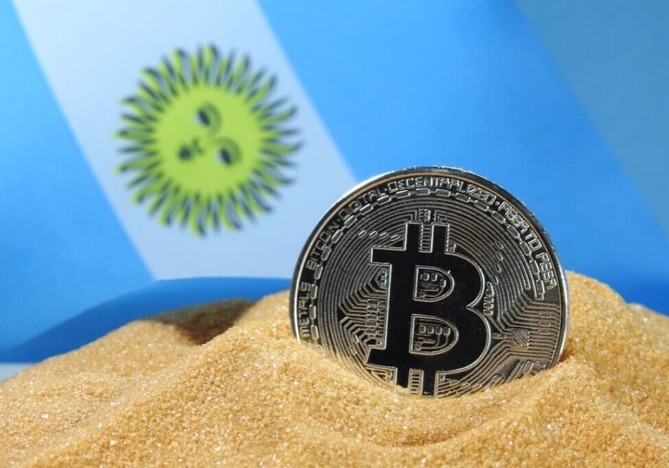 Bitcoin in sand with Argentina flag background