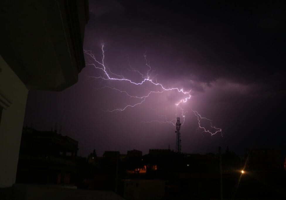 Lightning storm over dark cityscape skyline