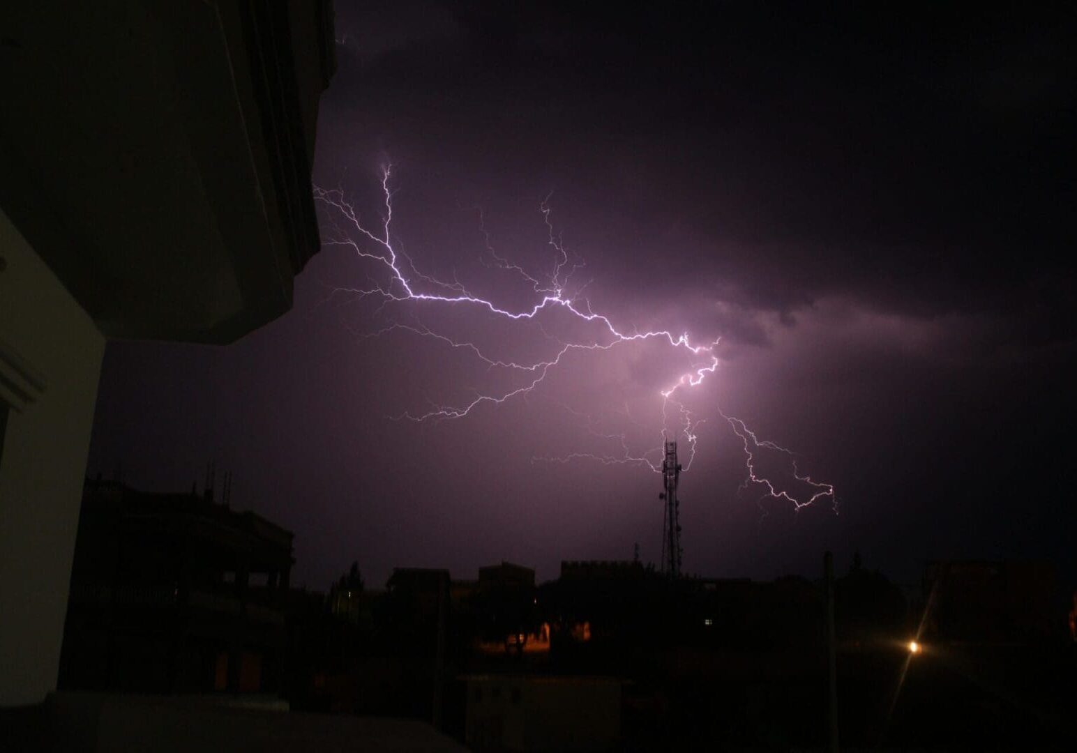 Lightning storm over dark cityscape skyline