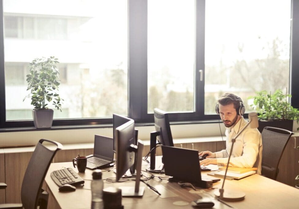 office-worker-on-computer-with-headphones-scaled
