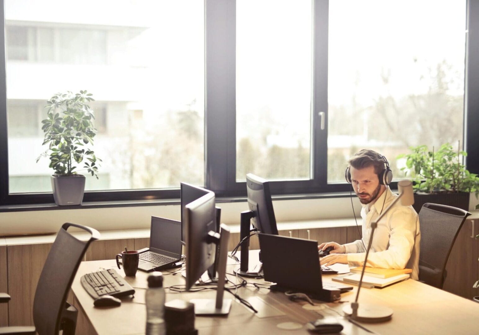 office-worker-on-computer-with-headphones-scaled